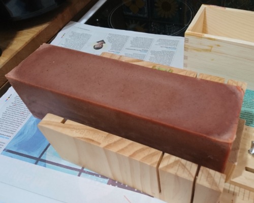 Handmade soap unmoulded and on a soap cutter.