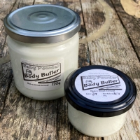 2 clear glass jars, one small, one large, filled with body butter.