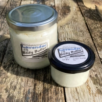 2 clear glass jars, one large, one small, containing body butter